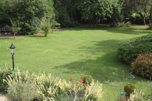 a large yard with a green lawn with flowers at The Rectory Lacock - Boutique Bed and Breakfast in Lacock