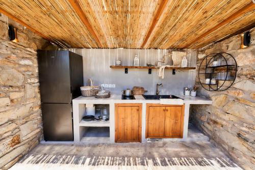 a kitchen with a sink and a refrigerator at Billion Stars in Thymonia Beach