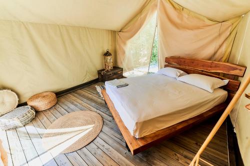 a bedroom with a bed in a tent at Billion Stars in Thymonia Beach