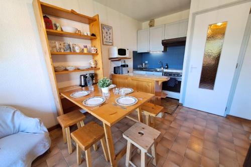 a kitchen with a wooden table and chairs in a room at Studio at the foot of the ice rink in Le Grand-Bornand