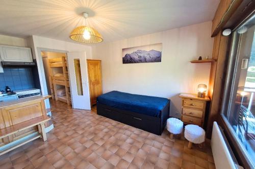 a bedroom with a blue bed in a room at Studio at the foot of the ice rink in Le Grand-Bornand