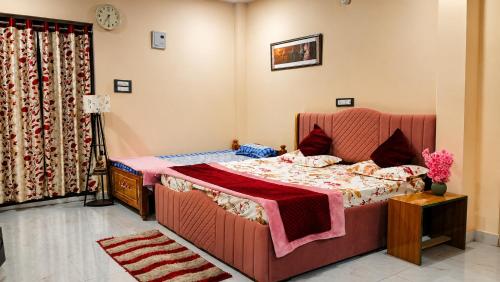 a bedroom with a bed with a red head board at Kasotiya Mansion Homestay in Surūrnagar