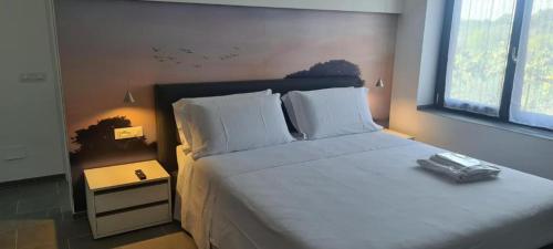 ein Schlafzimmer mit einem großen Bett mit weißen Laken und Kissen in der Unterkunft Piccolo Feudo Green Resort only adult in Viterbo