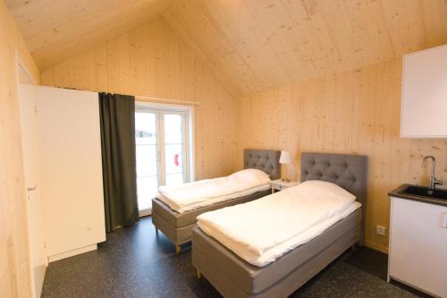 two beds sitting in a room with a window at Bygdsiljums Sjöbodar in Bygdsiljum