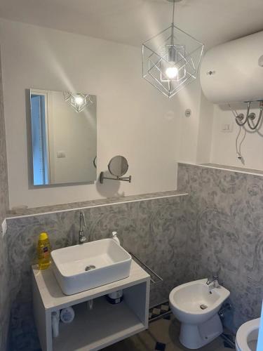 a bathroom with a sink and a toilet and a mirror at Lungarno Suite in Pisa