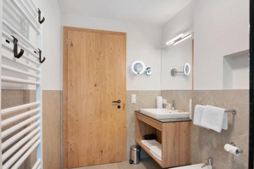 a bathroom with a wooden door and a sink at Residence Froy in Resia