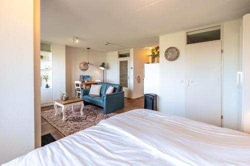 a bedroom with a bed and a chair and a table at Appartementencomplex Juliana 108 in De Koog