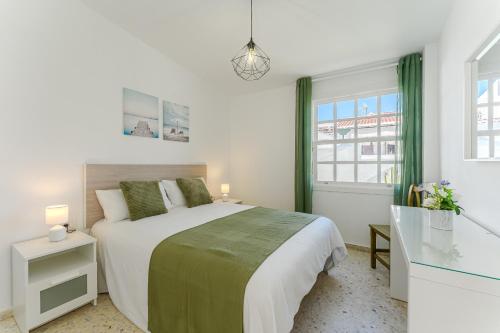 a white bedroom with a bed and a window at BUNGALOW ATALAYA in Abades