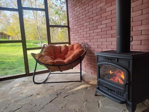 a fireplace with a chair next to a brick wall at Jvarisa Glamping in Ambrolauri