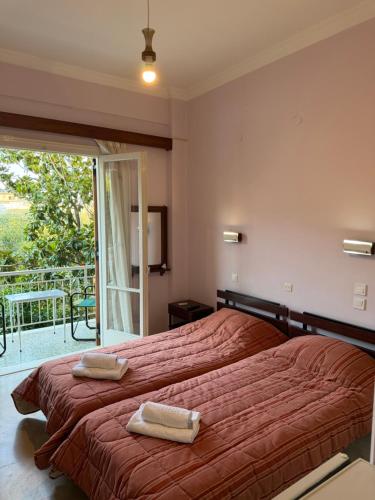 a bedroom with a bed with two towels on it at Puente Rooms in Methana