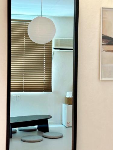 a room with a refrigerator and a table and a mirror at 브릭스테이 brikstay in Gyeongju