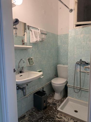 a bathroom with a sink and a toilet at Puente Rooms in Methana