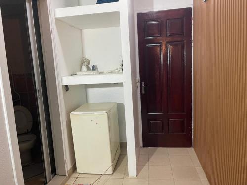 a bathroom with a toilet and a sink and a door at Lux meublé in Douala