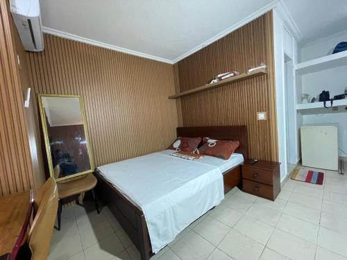 a small bedroom with a bed and a mirror at Lux meublé in Douala