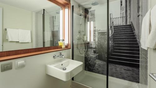 a bathroom with a sink and a shower at Campanile NATURE - Biarritz in Biarritz