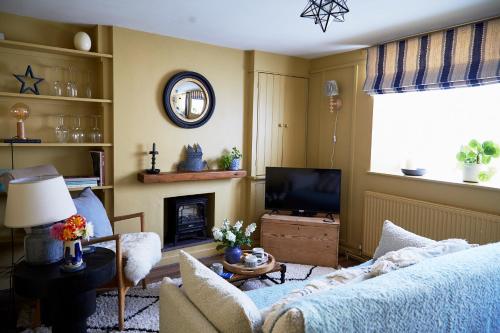 a living room with a couch and a television at NEW Stylish Cosy Dog Friendly Cottage Parking Central in Oundle