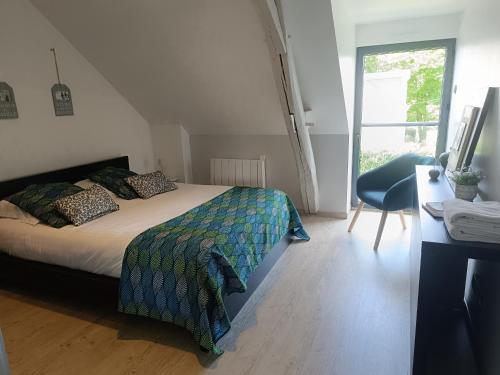 a bedroom with a bed and a desk and a window at Petite pom in Azay-le-Rideau