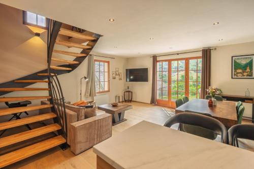 a living room with a spiral staircase and a table at Les Chalets de l'Ours in Cauterets