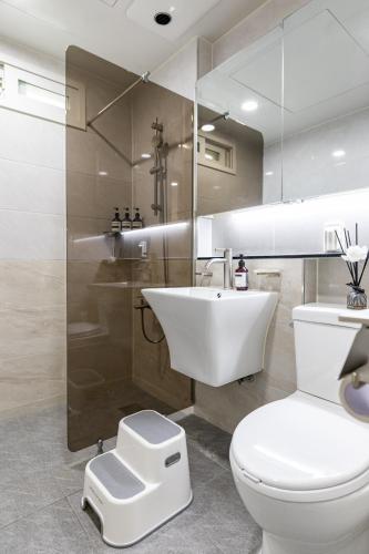 a bathroom with a white toilet and a sink at 김포공항ㆍ까치산역ㆍ최대11명ㆍ3룸화2ㆍ각방에어컨ㆍ2층독채 in Seoul