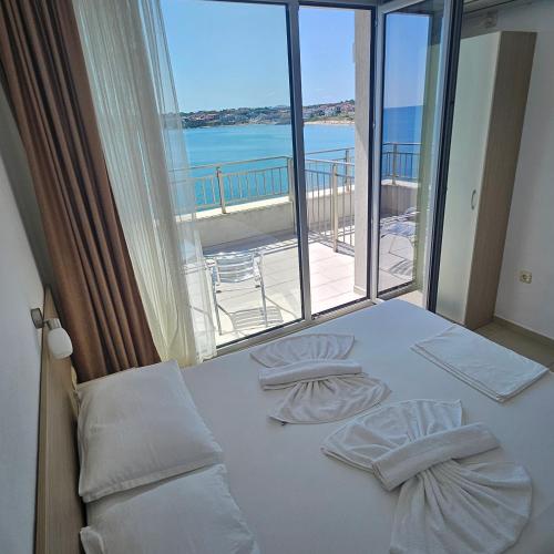 a bedroom with a bed with a view of the ocean at HARMONY in Sozopol