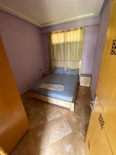 a small bedroom with a bed and a window at La ferme labyed in Fez
