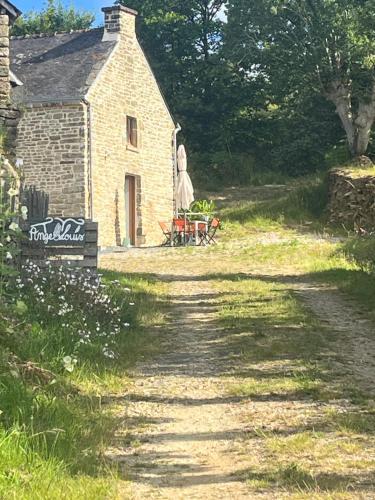 a dirt road leading to a stone house at TyAngeLLouis in Brandivy