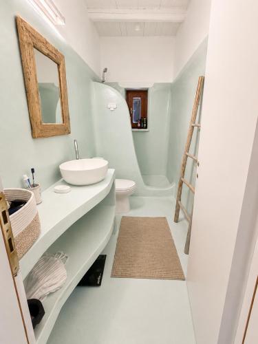 a bathroom with a sink and a mirror and a ladder at villa kite paros in Pounda