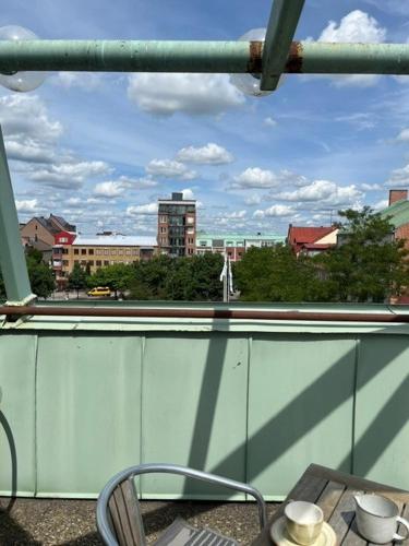 a table and chair on a balcony with a view of a city at Hotel Stensson in Eslöv