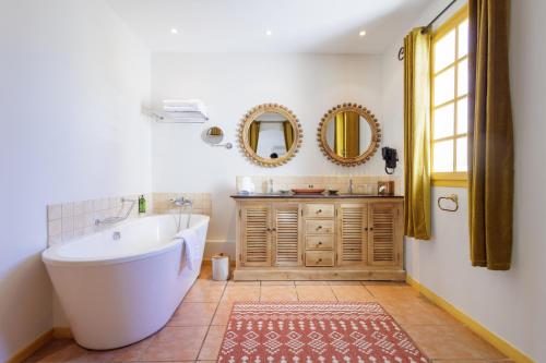 a bathroom with a tub and a sink and mirror at Hôtel La Villa Sainte Valérie Adults Only in Juan-les-Pins