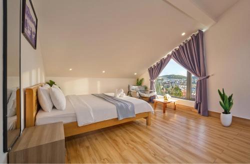 a bedroom with a large bed and a large window at Duck House in Da Thien
