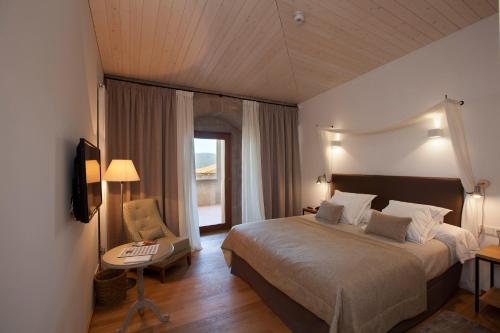 a bedroom with a large bed and a window at Parador Castillo de Monterrei in Monterrei