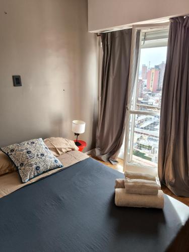 a bedroom with a bed and a large window at Espacio San Martin - Departamento en plena peatonal con Seguridad 24 hs in Santa Fe