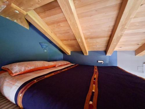 a bed in a room with wooden ceilings at Apartment Rosa Istria in Buje