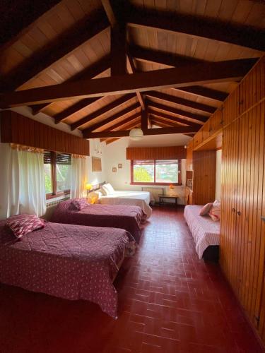 a room with four beds in a room with wooden ceilings at Cruz del Sur in Pinamar