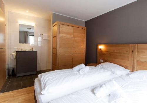 a bedroom with two beds with white sheets at Appart Laijola in Gaschurn