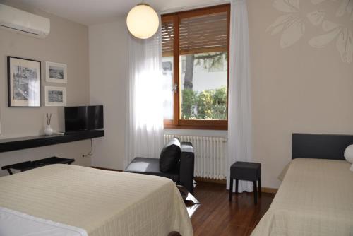 a bedroom with two beds and a chair and a window at Bed And Breakfast 22 Garibaldi Home in Riccione