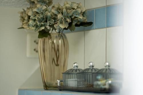 a vase with flowers on a shelf with two birds at peaceful tiny house near forest in Rorschacherberg