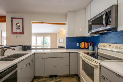 a kitchen with white cabinets and a sink at The Woods 8 in Copper Mountain