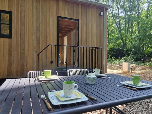 a wooden table with plates and cups on a patio at oud in Zonnebeke