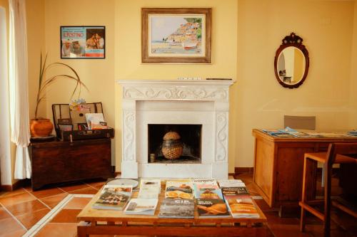 a living room with a fireplace and a table with books at Bed & Breakfast Spigolatrice in Sapri