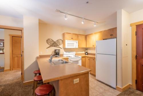 a kitchen with a sink and a white refrigerator at Copper Springs Lodge 107 in Copper Mountain