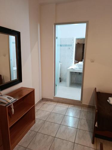 a bathroom with a large mirror and a sink at SmallHotel - Vevi in Vévi