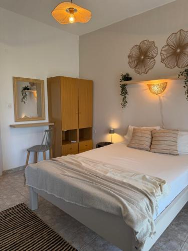 a bedroom with a large bed and a chair at The Beach House in Vasilika