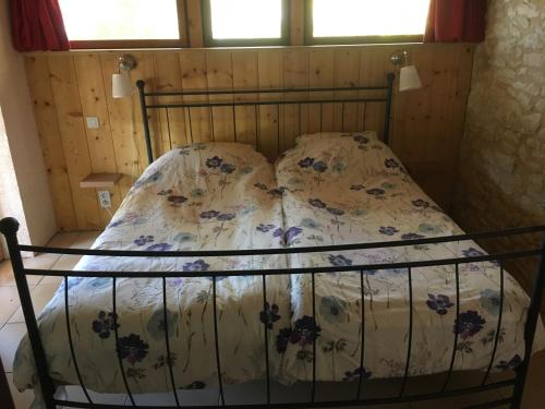 a bed with a floral bedspread and two pillows at Cezanne in Douzains