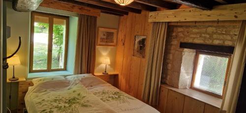 a bedroom with a bed in a room with wooden walls at Monet in Douzains