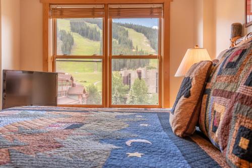 a bedroom with a large window and a tv at Copper Springs Lodge 433 in Copper Mountain