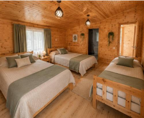 a bedroom with two beds in a log cabin at Ioane's Chalet in Mestia