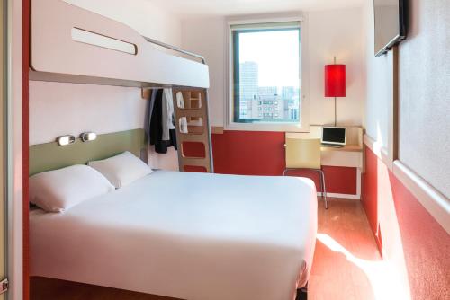 a bedroom with a bed and a desk with a computer at Ibis Budget Lyon Centre - Gare Part Dieu in Lyon