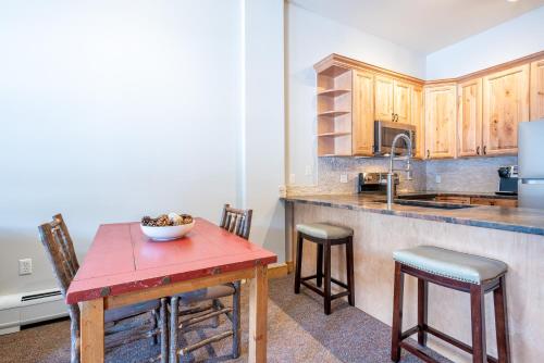a kitchen with a table with a bowl of fruit on it at Copper Springs Lodge 404 in Copper Mountain