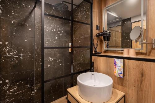 a bathroom with a sink and a black wall at Sure Hotel by Best Western Dijon Sud in Chenôve